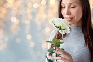 Woman sniffing a flower, suffering from allergies