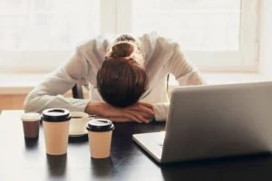 Young person at work suffering fromchronic fatigue syndrome symptoms