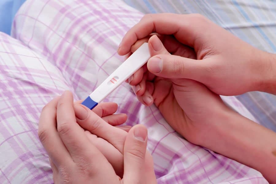 A woman holding a pregnancy test in her hands