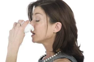 Woman holding her nose. The connection between allergies and alzheimer