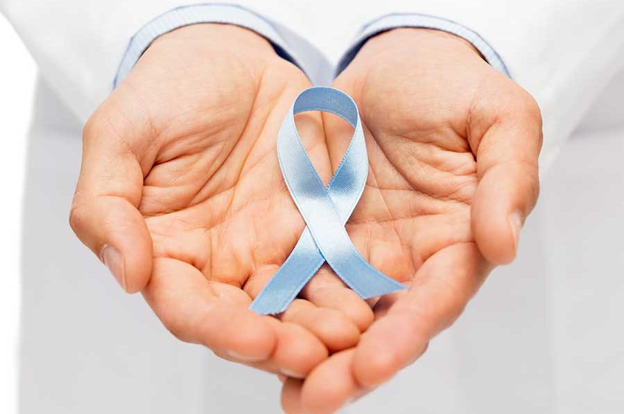 A man holding a blue ribbon in his hands, symbolizing prostate cancer
