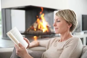 A woman reading by the fire. Ozone therapy restored her vision.