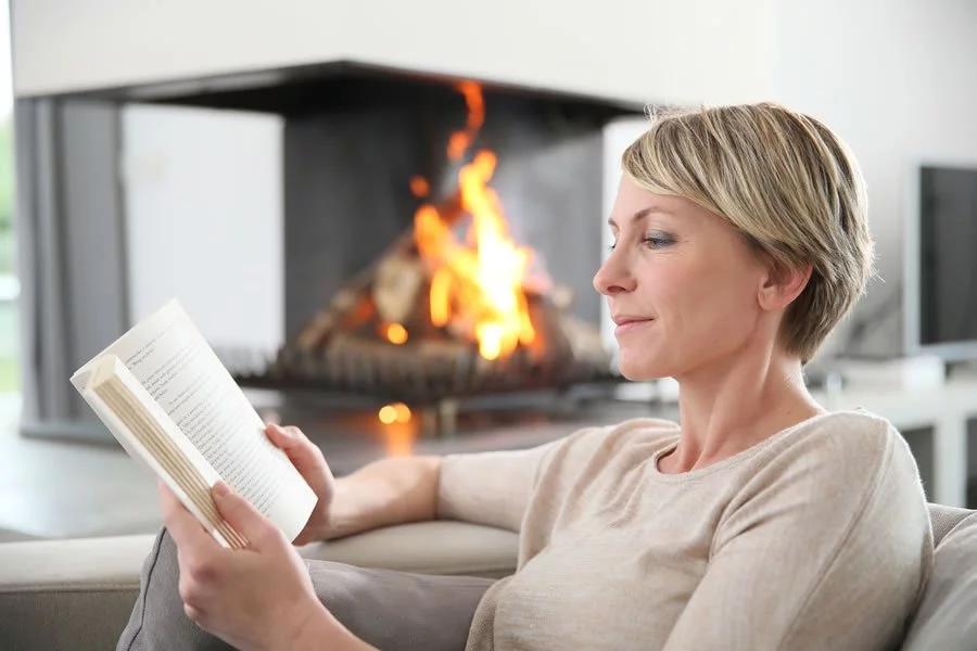 A woman reading by the fire. Ozone therapy restored her vision.