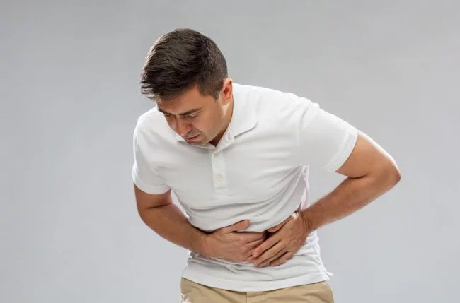 Unhappy man suffering from stomach ache. We treat GERD naturally