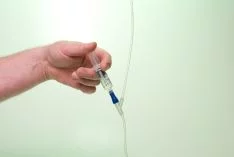 Doctor's hand administering iv nutrition to a patient. Iv therapy success story