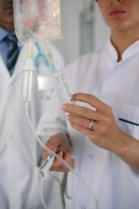 Doctors preparing to administer nutritional IV therapy to a patient