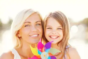 Happy mother and child girl with pinwheel toy. Denise's success story