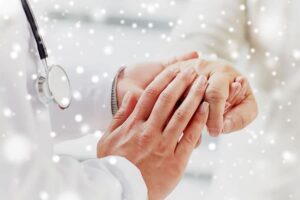 A patient holding the doctor's hand as a sign of gratitude