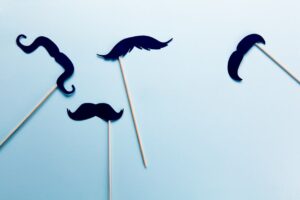 Movember mustaches on a blue background.