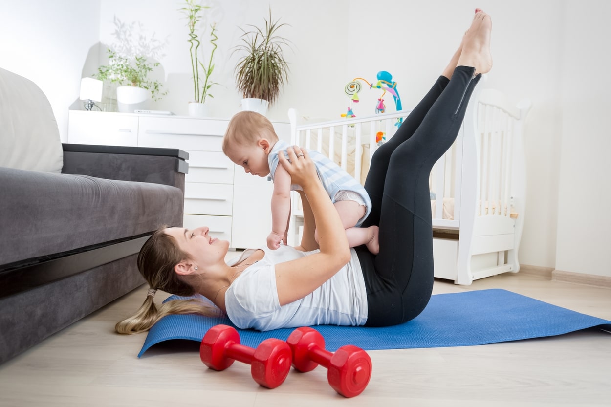 woman and baby on yoga mat stretching