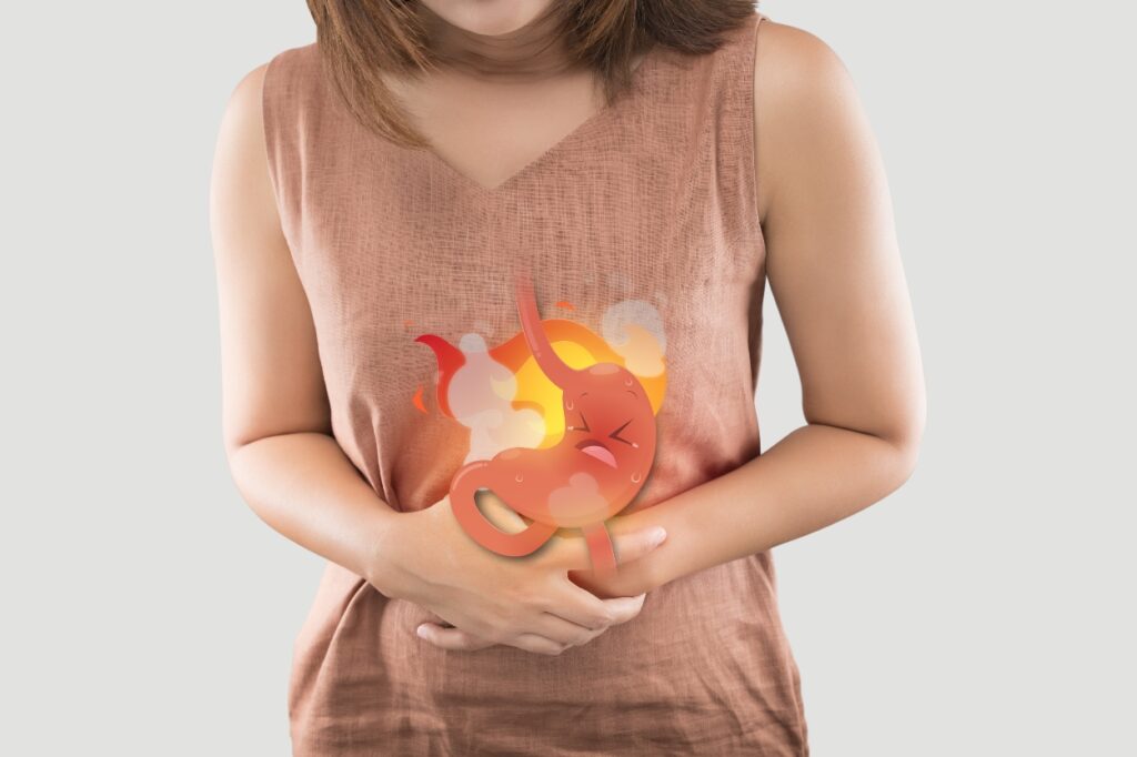 person holding stomach that is showing inflammation because of lack of digestive enzymes